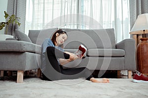 After workout of Young asian woman sitting take off her tight shoes after exercise in the living room