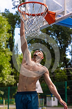 Workout. Young strong man, male basketball player training at street public stadium, sport court or palyground outdoors