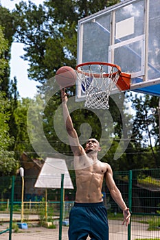 Workout. Young strong man, male basketball player training at street public stadium, sport court or palyground outdoors