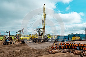 Workover rig working on a previously drilled well trying to restore production through repair. The pumping units and well workover photo