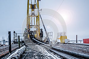 Workover rig working on a previously drilled well trying to restore production through repair. Toned photo