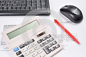 Workplace of accountant closeup: invoice, keyboard, calculator, computer mouse and pen