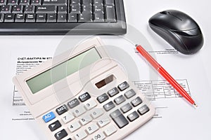 Workplace of accountant closeup: invoice, keyboard, calculator, mouse, and pen
