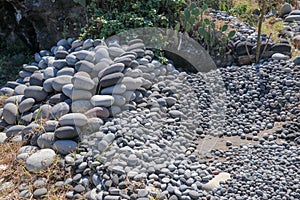 Workplace of Balinese stone gatherers. Sorted boulders by size. Natural building material. Hard work. Stones thrown from the sea a