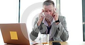 Workplace businessman suffering from hangover drinks alcohol