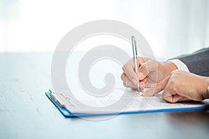 Workplace closeup person professional businesswoman sitting at desk hold pen signing or signature contract paper. Employee woman