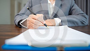 Workplace closeup person professional businesswoman sitting at desk hold pen signing or signature contract paper. Employee woman