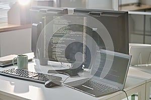Workplace of computers with codes on screen