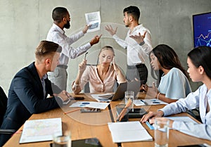 Workplace Conflicts. Stressed Group Of Business People Having Disagreements During Corporate Meeting photo