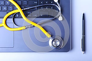 Workplace of doctor with laptop, stethoscope and RX prescription on white table. top view.