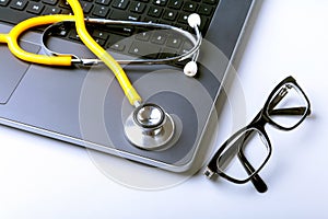 Workplace of doctor with laptop, stethoscope and RX prescription on white table. top view.