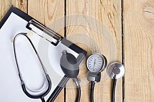 Workplace of a doctor. Medical clipboard and stethoscope on wooden desk background. Top view