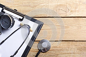 Workplace of a doctor. Medical clipboard and stethoscope on wooden desk background. Top view