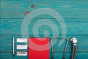 Workplace of doctor - stethoscope, medicine clipboard and pills