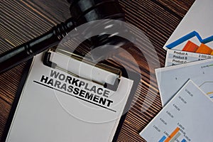 Workplace Harassement write on a paperwork isolated on Wooden Table. Law concept