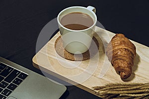 Workplace , Image of notebook computer with cup of coffee with croissant.