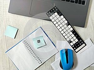 Workplace with laptop, blue wireless mouse, envelopes, notebook, office desk,