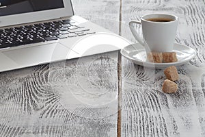 Workplace with laptop and coffeecup on white photo