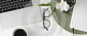 Workplace, laptop computer, smartphone, eyeglasses and headset on desk at home, panoramic banner.