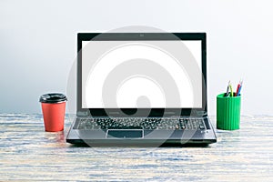 Workplace with laptop screen mockup, colored pens and coffee or tea on the table