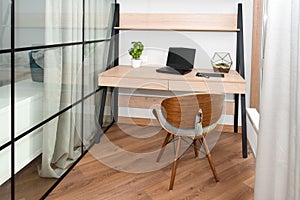 Workplace with laptop on the table. Comfortable work table in office near the window. Design of workplace in home office