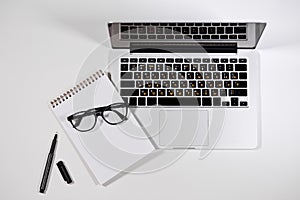 Workplace with Macbook, notebook, pen and glasses