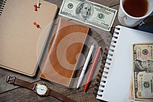 Workplace with money, stylish leather wallet, business things, pen, notebook on wooden table