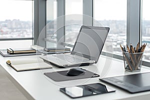 Workplace with notebook laptop Comfortable work table in office windows and city view.