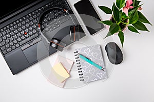 Workplace and office desk with laptop, headset and smarthpone