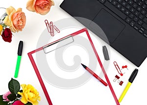 Workplace in office or home with computer, notebook, supplies, cup of tee and roses flowers. Space for modern creative work of