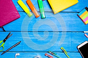 Workplace of the pupil of the school on a blue wooden table. Creative disorder, scattered pens and pencils. Place for text, nobody