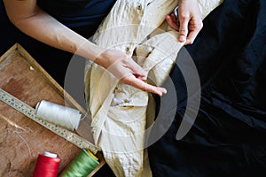 Workplace of seamstress. Dressmaker makingdetail, sew on buttons, spools of thread, tailor shop, tailoring, close up