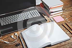 Workplace of student, secretary in office, manager. Laptop, books, headphones, notebook and stationery on a wooden table.