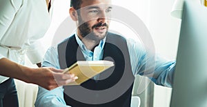 Workplace teamwork concept, Bearded young businessman working at office. Director man thinking looking in monitor computer