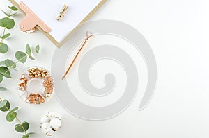 Workplace top view office tools and clipboard with cotton flowers and eucalyptus branches on a white background. Flat