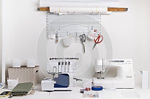 Workplace: White table with a sewing machine and an overlock for sewing.