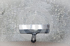 Workplace. working with spackling. Damaged wall repair. putty knife on gray grunge cement wall background. spatula for repair and