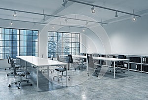 Workplaces in a bright modern loft open space office. Empty tables and docents' book shelves. Singapore panoramic view. A concept