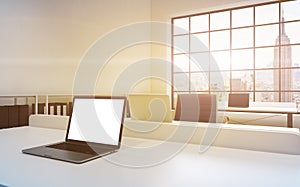 Workplaces in a bright modern loft open space office. Tables equipped with laptops, white copy space in the screen. Docs shelves.