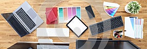 Workplaces in office table chairs tablet smartphone color palette pencils tablet keyboard monitors.