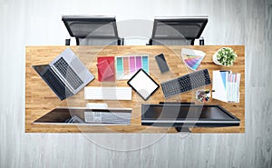 Workplaces in office table chairs tablet smartphone color palette pencils tablet keyboard monitors.