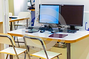 workplaces at one table with two computers in a large shopping center.