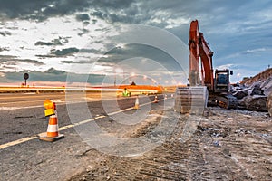 Works of extension of a road with excavator and delimited by safety cones