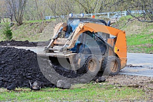 Works on the improvement of the park area. Skid steer loader