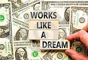 Works like a dream symbol. Concept words Works like a dream on wooden cubes. Beautiful background from dollar bills. Businessman