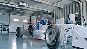 Workshop employees are checking a racing car