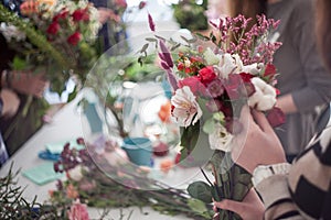Workshop florist, making bouquets and flower arrangements. Soft focus