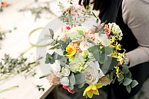 Workshop florist, making bouquets and flower arrangements. Woman collecting a bouquet of flowers. Soft focus