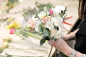 Workshop florist, making bouquets and flower arrangements. Woman collecting a bouquet of flowers. Soft focus