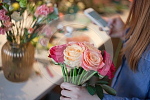 Workshop florist, making bouquets and flower arrangements. Woman collecting a bouquet of roses. Soft focus